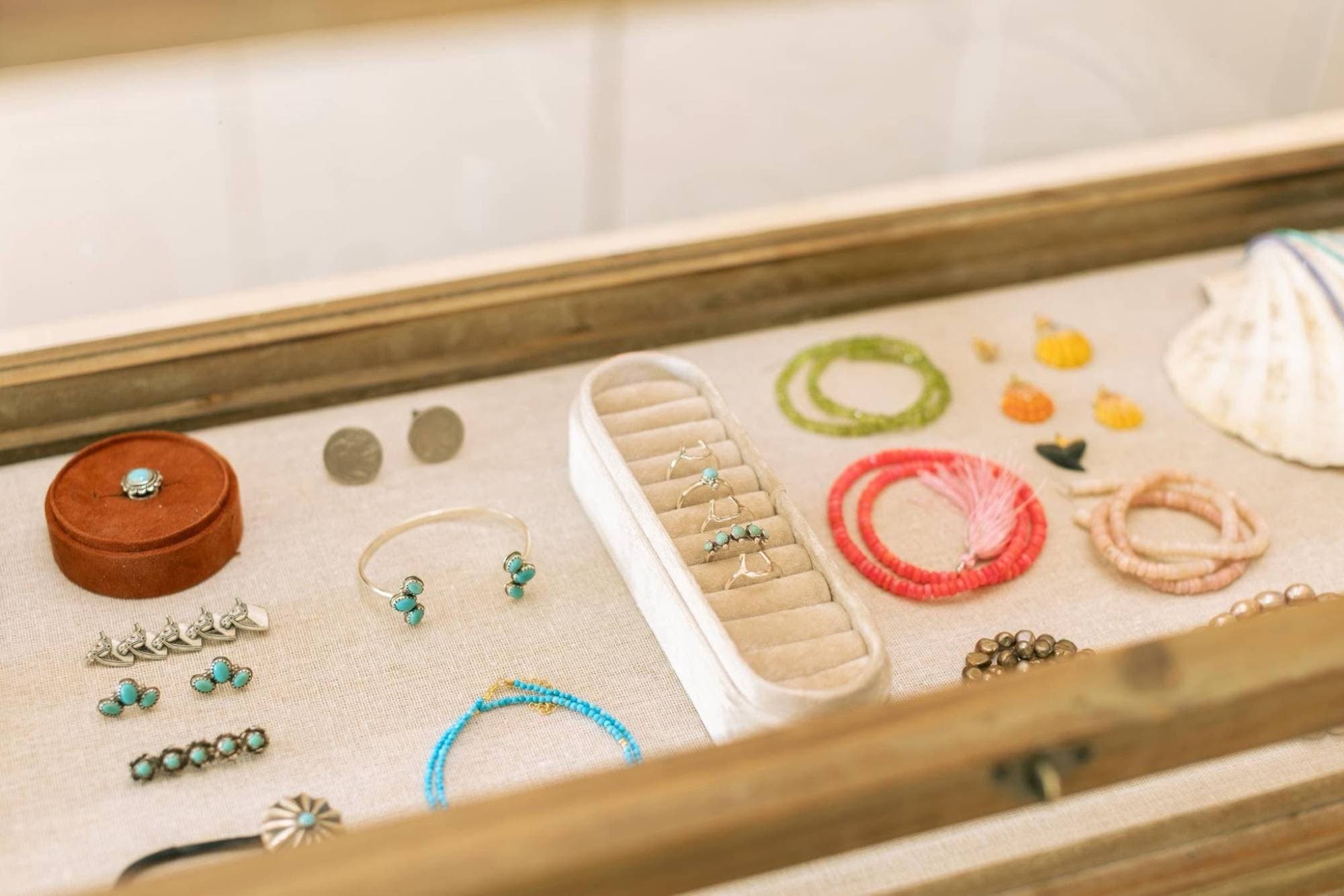 sea & west jewelry case — turquoise silver rings, cuffs and earrings, beaded bracelets and shell earrings on linen